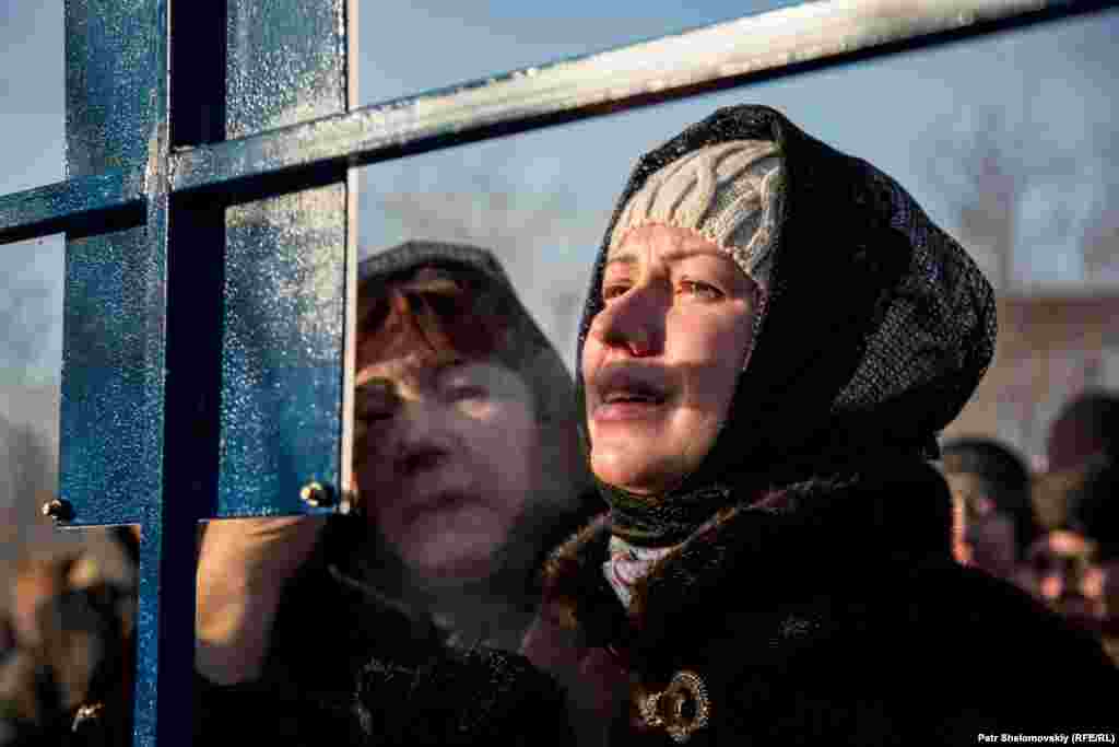 The widow of miner Vitaliy Nezhelskiy cries in front of a memorial.&nbsp;