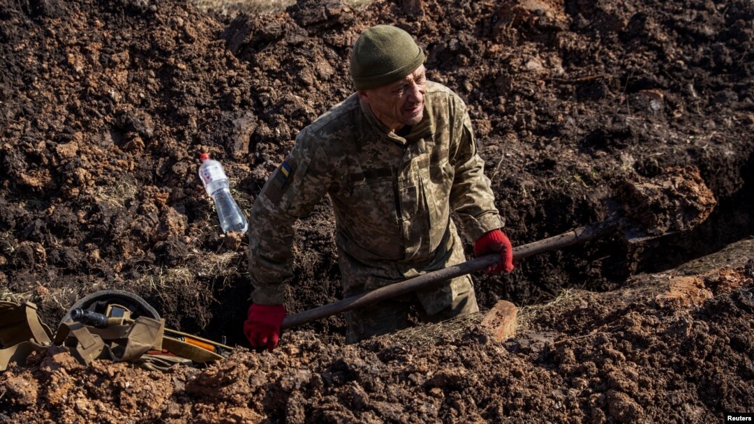 Un militar ucrainean sapă un șanț în afara orașului Bahmut, în Donețk, pe 4 martie 2023. 