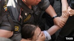 Police detain an opposition supporter during a protest in Moscow on May 31.