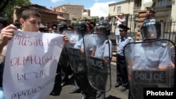 Armenia - A protester outside the presidential palace in Yerevan holds a poster demanding "punishment" for businessman Ruben Hayrapetitian and his bodyguards, 1Jul2012.