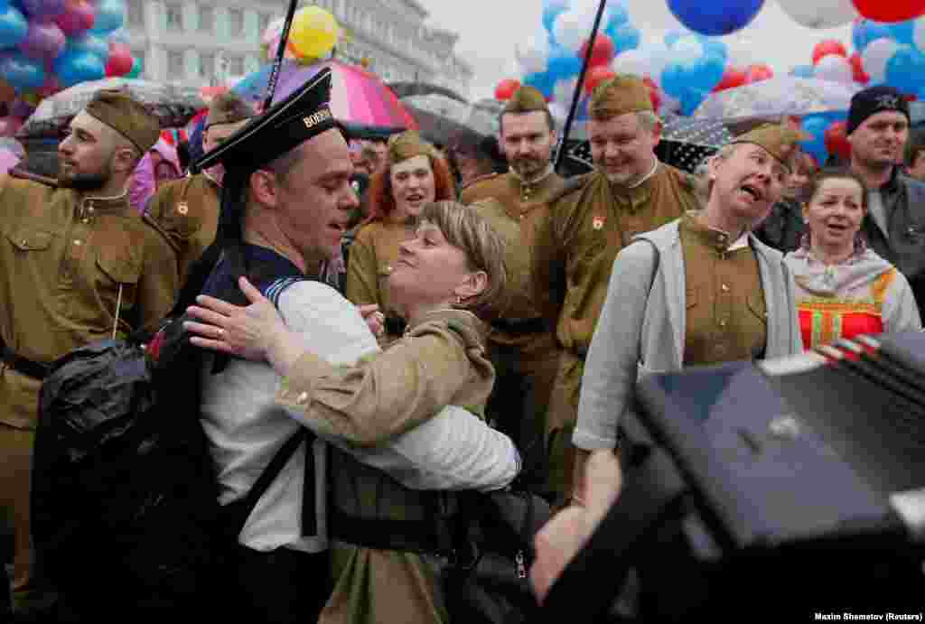 Moskwanyň merkezinde taryhy harby lybaslary geýip, Maý gününde tans edýän jübüt. 1-nji maý. (Reuters/Maxim Shemetov)