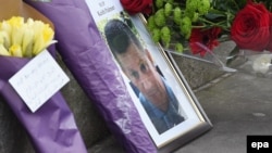 A makeshift memorial to the victims of the terror attack includes a photograph of British policeman Keith Palmer, who was stabbed to death by the assailant.