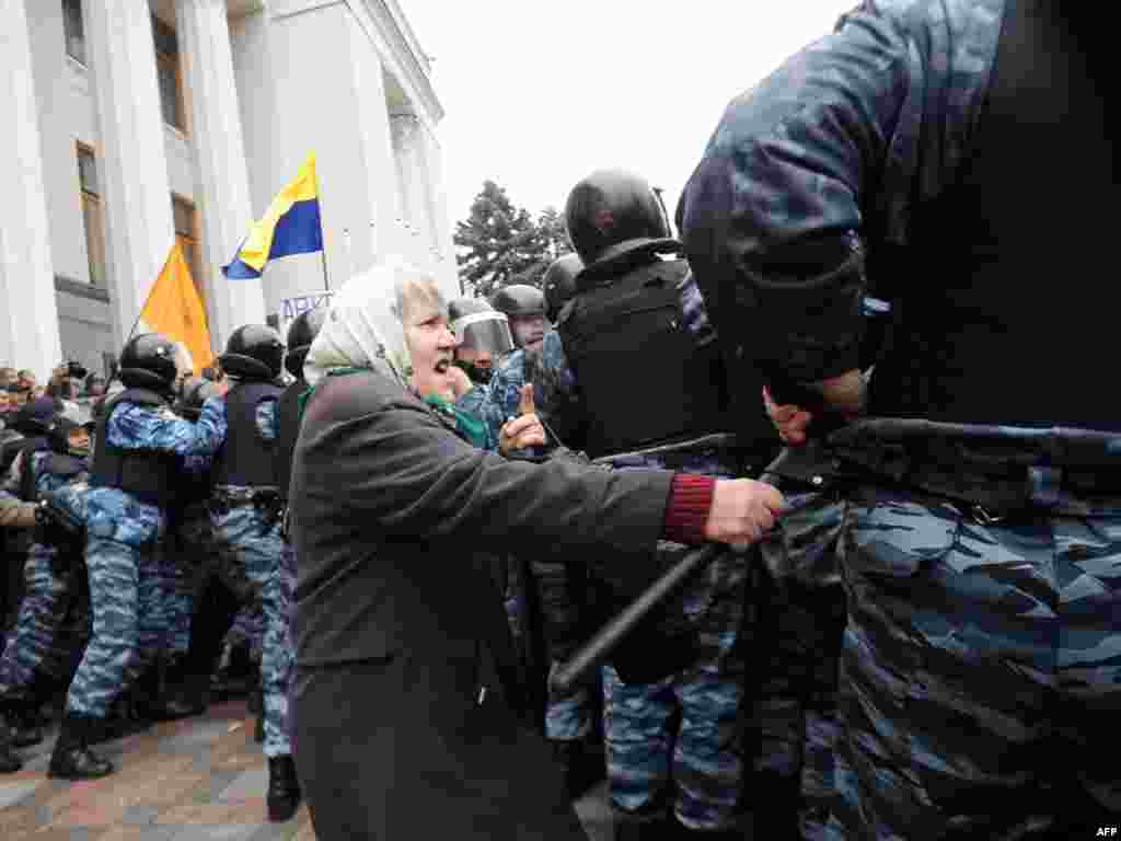 O femeie in varsta infruntand politia in timpul protestelor din fata parlamentului la Kiev, Ucraina. (Sergey Polezhaka pentru AFP) 