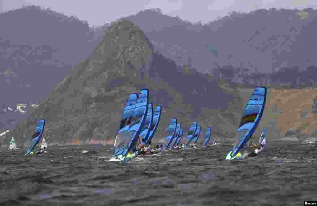 Men&#39;s windsurfing competitors battle a stiff breeze.&nbsp;