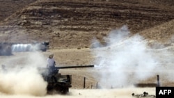 National Transitional Council fighters fire their small caliber cannon positioned on the front line near the city of Bani Walid on September 13.