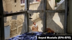 A resident survey the damage caused after rockets landed at a residential area in Ghazni on July 16.