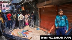 Сотрудник полиции стоит возле обломков, которые упали с поврежденного здания в результате землетрясения в Дакке, Бангладеш, 21 ноября 2025 года