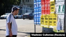 A man stands views campaign posters ahead of the upcoming parliamentary elections in Moldova, in Chisinau on September 21.