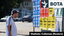 Një burrë shikon posterat e fushatës para zgjedhjeve të ardhshme parlamentare në Moldavi, në Kishinjev, 21 shtator.