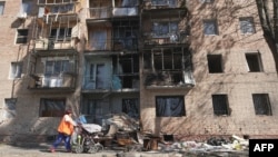 A woman walks past a building damaged by Ukrainian strikes in Kursk on August 16.