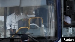 Găuri de gloanțe în parbrizul autobuzului în care a avut loc atacul.