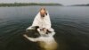 An Orthodox priest baptizes a woman in the Yenisei River during a ceremony marking the Christianization of the country in Krasnoyarsk.