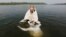 An Orthodox priest baptizes a woman in the Yenisei River during a ceremony marking the Christianization of the country in Krasnoyarsk.