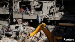 People gather at the site of an Israeli air strike in Beirut on October 11. 