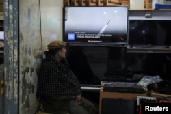 A man in Peshawar, Pakistan, watches a news channel on television inside a shop after the Foreign Ministry announced the country had conducted air strikes inside Iran targeting separatist militants on January 18.