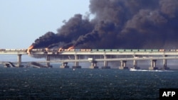 Пожар на Керченском (Крымском) мосту на рассвете в Керченском проливе. 8 октября 2022 года