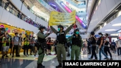 Policija u Hong Kongu sa plakatom upozorenja 