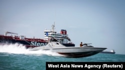 A boat of the Iranian Revolutionary Guard sails near to Stena Impero, a British-flagged vessel owned by Stena Bulk, in Iranian waters, August 22, 2019