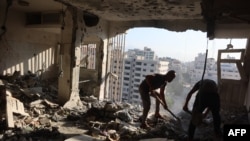 فلسطینیان روز ۱۱ مرداد ۱۴۰۵ وسایل باقی‌مانده خود را از آپارتمانی در شهر غزه که در حملات شبانه اسرائیل هدف قرار گرفت، خارج می‌کنند
