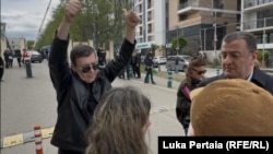 უცნობი პირი ზვიად კორძაძესთან, სასამართლოს შესასვლელთან