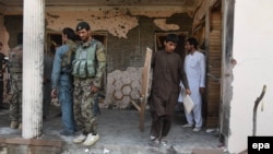 Local people and policemen inspect a house after a suicide attack on a tribal council in the outskirts of Jalalabad on October 31.