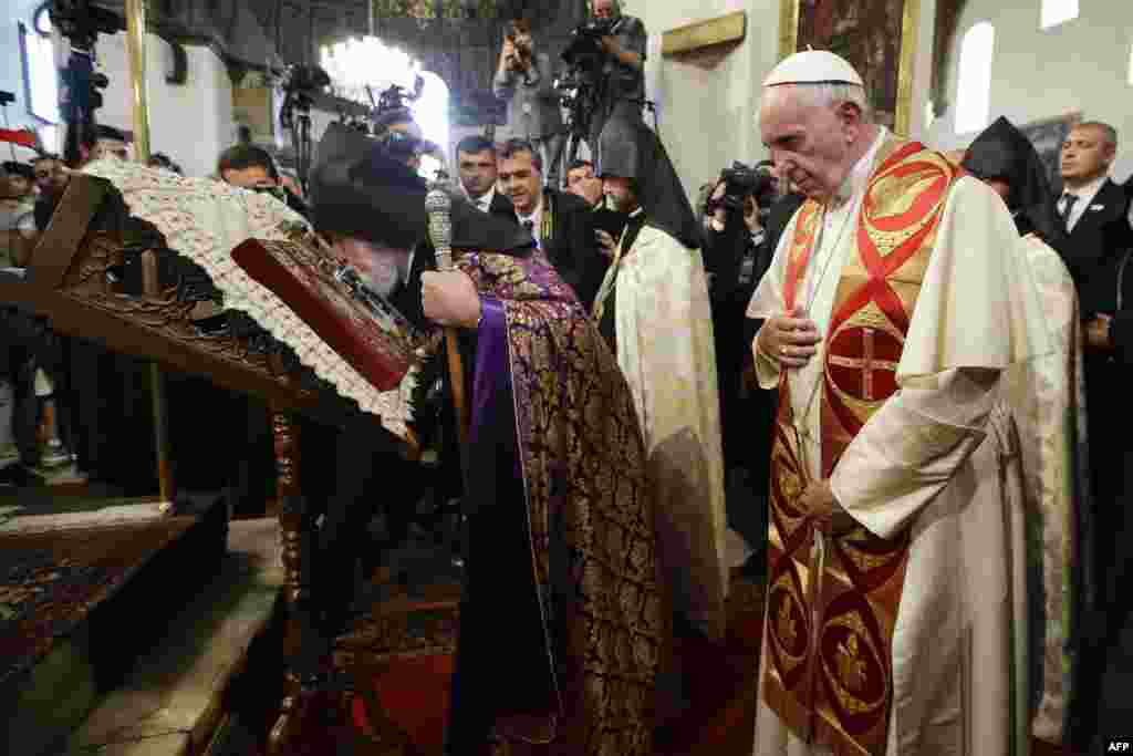 Armenia -- Catholicos Karekin II, left, flanked by Pope Francis, kisses a Holy Book as he visits the Apostolic Cathedral of Etchmiadzin in Yerevan, on June 24, 2016. 