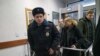 Дмитрий Семеновский (в черной куртке) проходит на суд над семьей координатора "Открытой России"