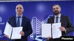 Armenia - Economy Minister Gevorg Papoyan (right) and Lydian Armenia CEO Hayk Aloyan sign a share transfer agreement in Yerevan, December 27, 2024.