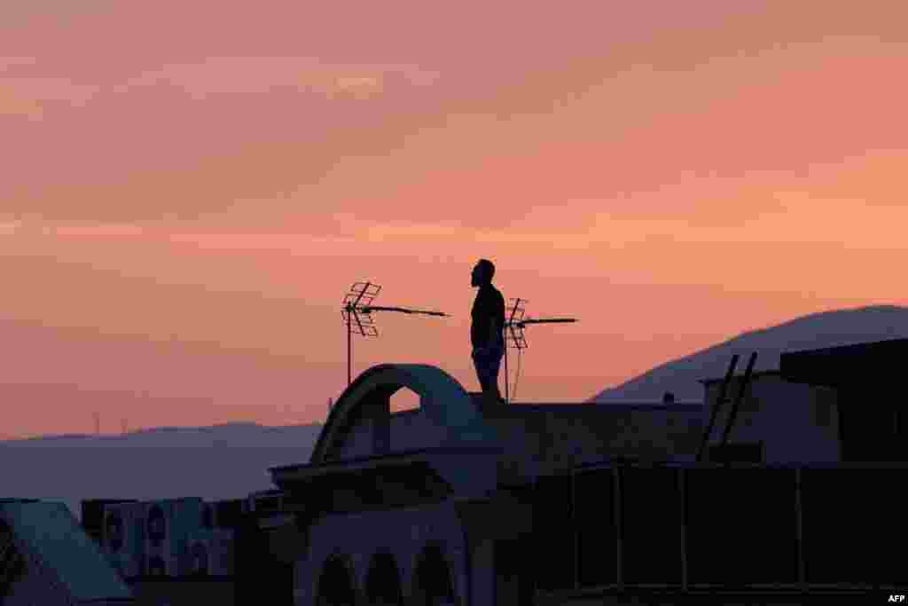 A man stands on the roof of a building while watching the horizon in Tehran amid ongoing Israeli air strikes on the city.