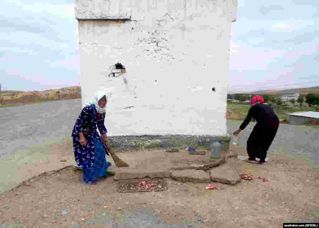 Satyjy zenanlar balykdan galan hapa-hupalary arassalaýarlar.