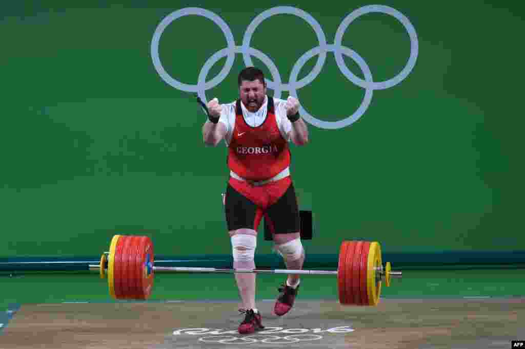 Georgia&#39;s Lasha Talakhadze celebrates after winning gold in the men&#39;s 105-kilogram+ weightlifting.