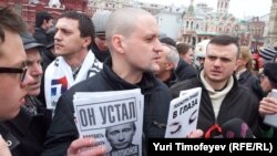 Сергій Удальцов у Москві тримає плакат «Він втомився» зі зображенням Путіна