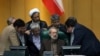 Iranian parliament speaker Ali Larijani, seated at center, talks with a group of lawmakers in a session of parliament to debate the proposed cabinet by President Hassan Rouhani, in Tehran, Iran, Thursday, Aug. 17, 2017.