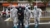 China -- Medical staff members wear protective clothing to help stop the spread of a deadly virus accompanying a patient as they walk into a hospital in Wuhan, January 26, 2020.