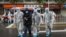 China -- Medical staff members wear protective clothing to help stop the spread of a deadly virus accompanying a patient as they walk into a hospital in Wuhan, January 26, 2020.