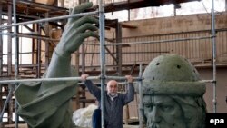 Russian artist Salavat Scherbakov climbs the scaffolding around his model for a monument of St. Vladimir at a workshop in Moscow on May 28, 2015.