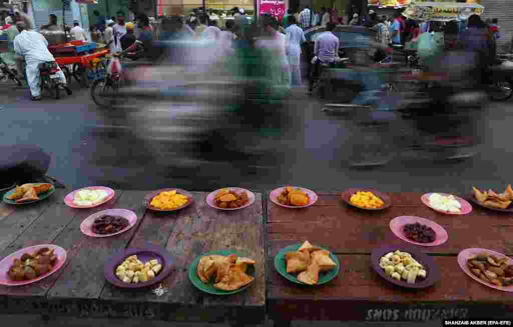 Free food is placed on tables on a roadside in Karachi, Pakistan, as the time to break the Ramadan approaches. (epa-EFE/Shahzaib Akber)