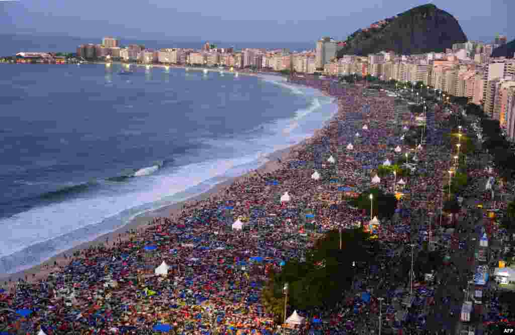 Catholic pilgrims attending World Youth Day crowd Copacabana Beach in Rio de Janeiro after spending the night sleeping there following a prayer vigil headed by Pope Francis. (AFP/Vanderlei Almeida)