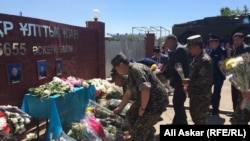 Люди возлагают цветы у воинской части, на которую было совершено вооруженное нападение, в результате чего погибли несколько человек. Актобе, 9 июня 2016 года.
