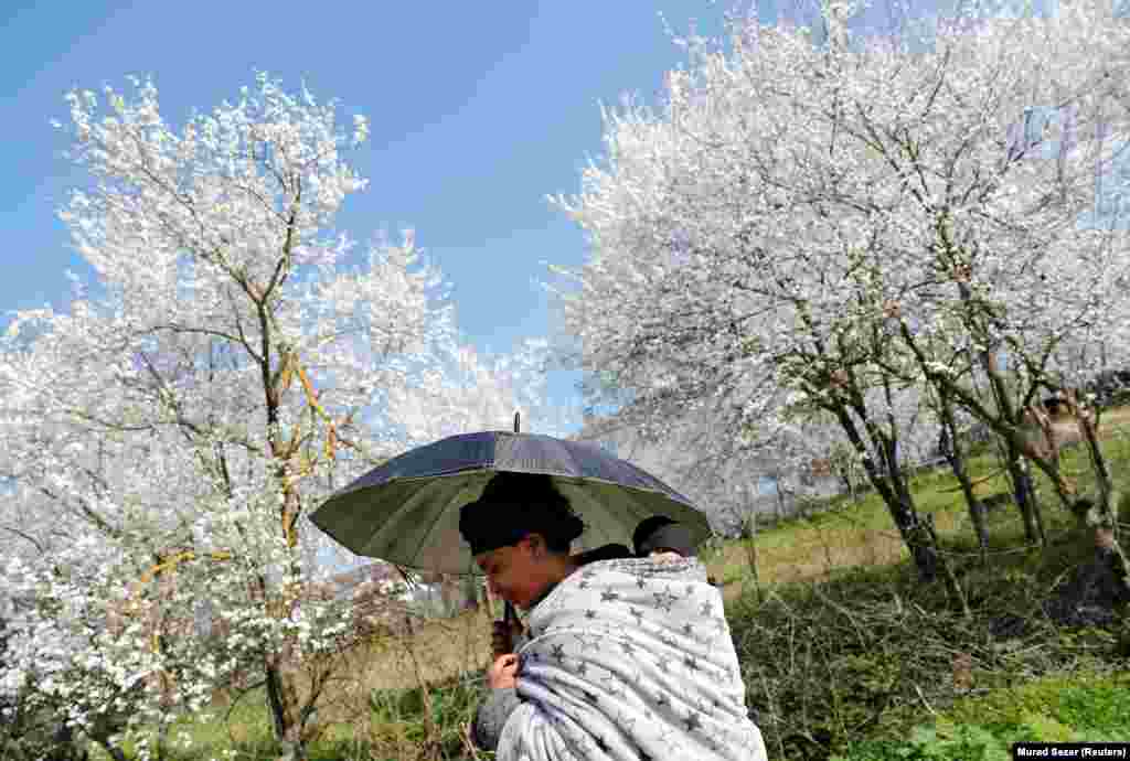 A migrant from Eritrea carries her child in a village near the Turkish-Greek border in Edirne Province, Turkey. (Reuters/Murad Sezer)