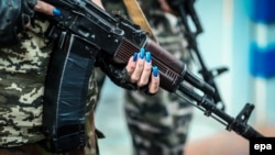 A member of the self-declared Donetsk People's Republic militia holds a Kalashnikov automatic rifle at a checkpoint in Donetsk on August 15.