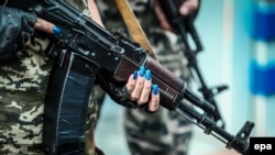 A member of the self-declared Donetsk People's Republic militia holds a Kalashnikov automatic rifle at a checkpoint in Donetsk on August 15.