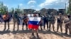Într-o captură preluată dintr-un videoclip și difuzată de Serviciul de presă al grupării de mercenari Wagner pe 20 mai, Evgheni Prigojin ține un steag rusesc în fața soldaților săi în Bahmut, Ucraina.