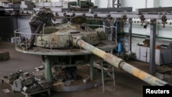 An employee works on a tank turret as armored vehicles are repaired at a Kyiv armored plant on August 14.