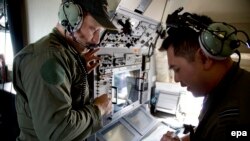 خدمه یکی از هواپیماهای نیروی هوایی استرالیا در حال جستجو برای یافتن نشانه‌ای از هواپیمای پرواز ۳۷۰ 