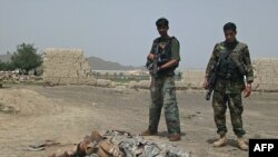 Afghan soldiers stand near the body of a suicide attacker near U.S. Camp Salerno on the outskirts of Khost city.