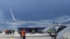 A reptéri személyzet és a biztonsági erők láthatók az aszfalton egy Ryanair-járat előtt, amely kénytelen leszállni Minszkben, 2021. május 23-án