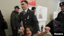 Поліцейський затримує активістку FEMEN