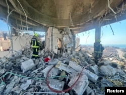 Bahrain civil defense and rescue personnel work in a residential building that the country's Interior Ministry says was hit by an Iranian drone on June 28.