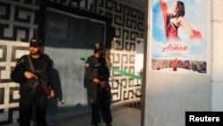 Pakistani policemen guard the entrance of a cinema at the site of a deadly attack in Peshawar on February 11.